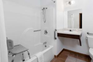 a white bathroom with a sink and a bath tub at Super 8 by Wyndham Winner SD in Winner