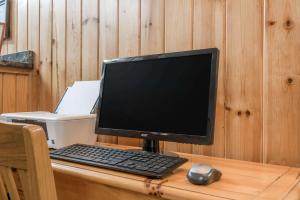 un monitor de ordenador y un teclado y ratón sobre un escritorio en Super 8 by Wyndham Baxter/Brainerd Area, en Baxter