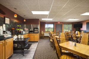 a restaurant with wooden tables and chairs and a counter at Super 8 by Wyndham Eveleth in Eveleth