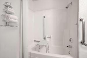 a white bathroom with a sink and a bath tub at Super 8 by Wyndham Willmar in Willmar +6 photos