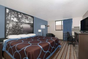 a hotel room with a bed and a flat screen tv at Super 8 by Wyndham Willmar in Willmar