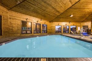 a large swimming pool in a building with a wooden ceiling at Super 8 by Wyndham Red Wing in Red Wing