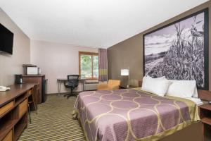a hotel room with a bed and a desk at Super 8 by Wyndham St. Cloud in Saint Cloud