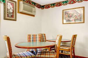 a dining room with two tables and chairs at Super 8 by Wyndham Chaska in Chaska