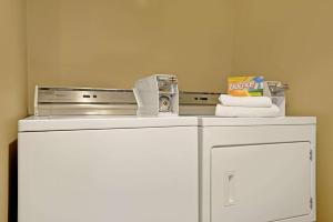 a small white refrigerator with a microwave and towels on top at Super 8 by Wyndham Melrose in Melrose +3 photos