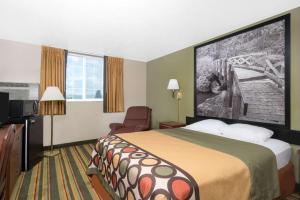 um quarto de hotel com uma cama e uma televisão em Super 8 by Wyndham Winona MN em Winona