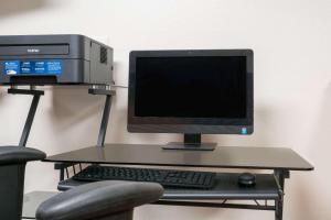 un monitor e una tastiera su una scrivania con sedia di Super 8 by Wyndham St. Cloud a Saint Cloud