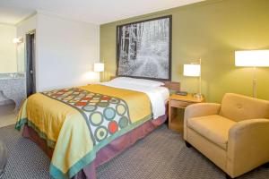 a hotel room with a bed and a chair at Super 8 by Wyndham Windsor/Madison North in Windsor