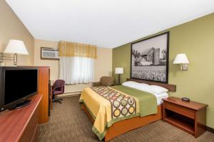 a hotel room with a bed and a flat screen tv at Super 8 by Wyndham Fairmont in Fairmont