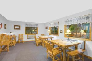 un comedor con mesas, sillas y ventanas en Super 8 by Wyndham Lake George/Warrensburg Area, en Warrensburg