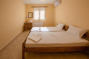阿爾戈斯托利的住宿－La Casa Di Nonna，一间卧室设有两张带白色床单的床和窗户。