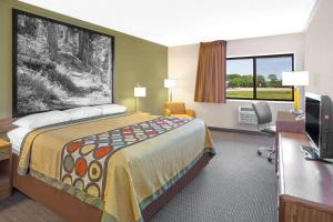 Habitación de hotel con cama grande y escritorio. en Super 8 by Wyndham Windsor/Madison North, en Windsor