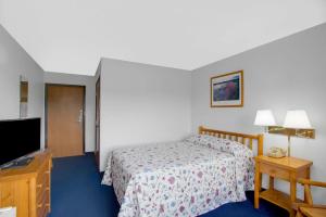 Een bed of bedden in een kamer bij Super 8 by Wyndham Lake George/Warrensburg Area