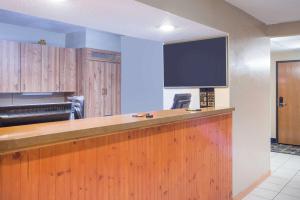a kitchen with a bar with a flat screen tv at Super 8 by Wyndham Massena NY in Massena