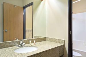 bagno con lavandino e specchio di Super 8 by Wyndham Hudson a Hudson