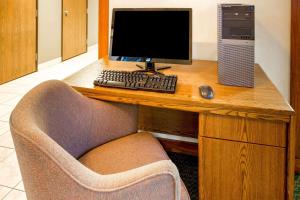 a desk with a computer and a keyboard and mouse at Super 8 by Wyndham Hartford WI in Hartford