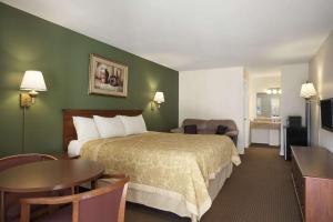 a hotel room with a bed and a table at Super 8 by Wyndham Mifflinville Near Bloomsburg in Mifflinville