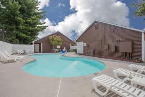 a swimming pool with chairs and a barn at Super 8 by Wyndham Christiansburg in Christiansburg
