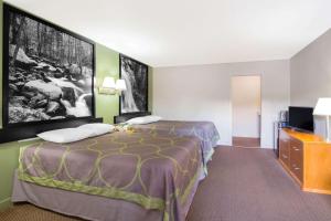 a hotel room with a bed and a flat screen tv at Super 8 by Wyndham Christiansburg in Christiansburg +37 photos
