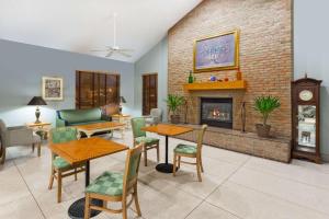 a living room with a fireplace and tables and chairs at Super 8 by Wyndham Wisconsin Dells in Wisconsin Dells