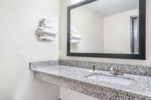 La salle de bains est pourvue d'un lavabo et d'un miroir. dans l'établissement Super 8 by Wyndham Rice Lake, à Rice Lake