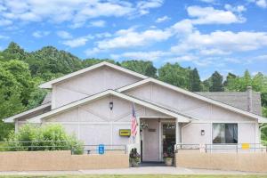 ein Haus mit einer Flagge davor in der Unterkunft Super 8 by Wyndham Pittsburgh PA Airport-University Area in Moon Township