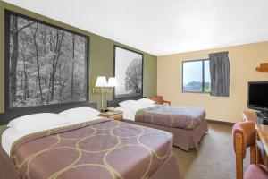 a hotel room with two beds and a flat screen tv at Super 8 by Wyndham Roanoke VA in Roanoke