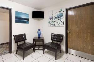 a waiting room with two chairs and a table and a television at Super 8 by Wyndham Hampton in Hampton