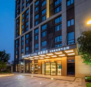 a large building with a sign in front of it at Mercure Shanghai Jiuting in Shang-hai