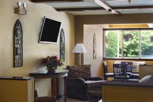 a living room with chairs and a tv on the wall at Super 8 by Wyndham Whitewater WI in Whitewater