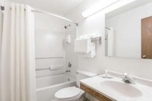 a white bathroom with a toilet and a sink at Super 8 by Wyndham Hampton in Hampton