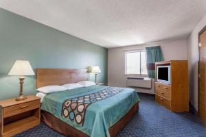 a hotel room with a bed and a television at Super 8 by Wyndham Richmond Midlothian Turnpike in Midlothian