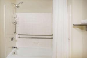 y baño con ducha y bañera con cortina de ducha. en Super 8 by Wyndham Salem VA, en Salem
