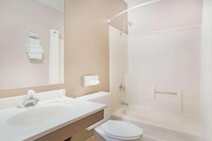 a white bathroom with a sink and a toilet at Super 8 by Wyndham Marshall MN in Marshall
