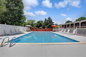 a swimming pool at a resort with chairs around it at Super 8 by Wyndham Williamsburg/Historic Area in Williamsburg +18 photos