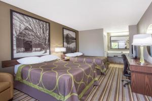 a hotel room with two beds and a desk at Super 8 by Wyndham Wytheville in Wytheville