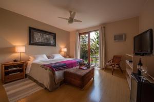 a bedroom with a bed and a flat screen tv at Pousada Maya in Alto Paraíso de Goiás
