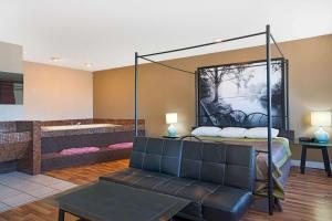 a living room with a bed and a couch at Super 8 by Wyndham Marshall MN in Marshall