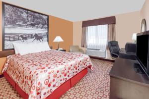 a hotel room with a bed and a flat screen tv at Super 8 South by Wyndham in Bowling Green