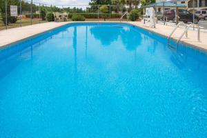 a large blue swimming pool with blue water at Super 8 by Wyndham Walterboro in Walterboro