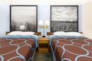 a hotel room with two beds and two nightstands at Super 8 by Wyndham Columbus in Columbus