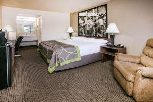 Habitación de hotel con cama y silla en Super 8 by Wyndham Oklahoma Airport Fairgrounds West, en Oklahoma City