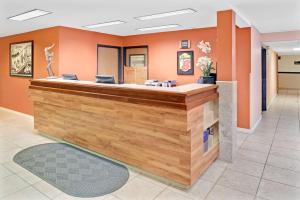 a lobby with orange walls and a reception counter at Super 8 by Wyndham Spokane/West in Airway Heights