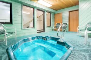 a hot tub in a room with chairs and a tv at Super 8 by Wyndham Lexington in Lexington