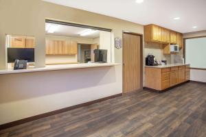 a large room with a kitchen with wooden cabinets at Super 8 by Wyndham Lewistown in Lewistown