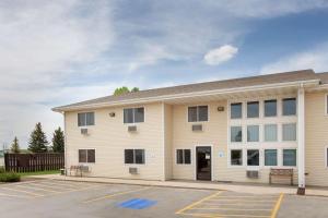 a large white building with a parking lot at Super 8 by Wyndham Lewistown in Lewistown