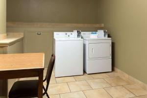 a small kitchen with a white refrigerator and a table at Super 8 by Wyndham Radcliff Ft. Knox Area in Radcliff