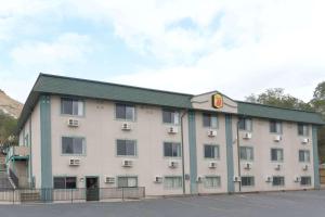 a large white building with a green roof at Super 8 by Wyndham Green River in Green River