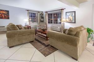 sala de estar con 2 sillas y mesa en Super 8 by Wyndham West Monroe en West Monroe