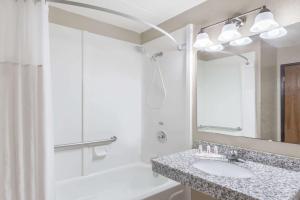 een witte badkamer met een wastafel en een douche bij Super 8 by Wyndham Logansport in Logansport